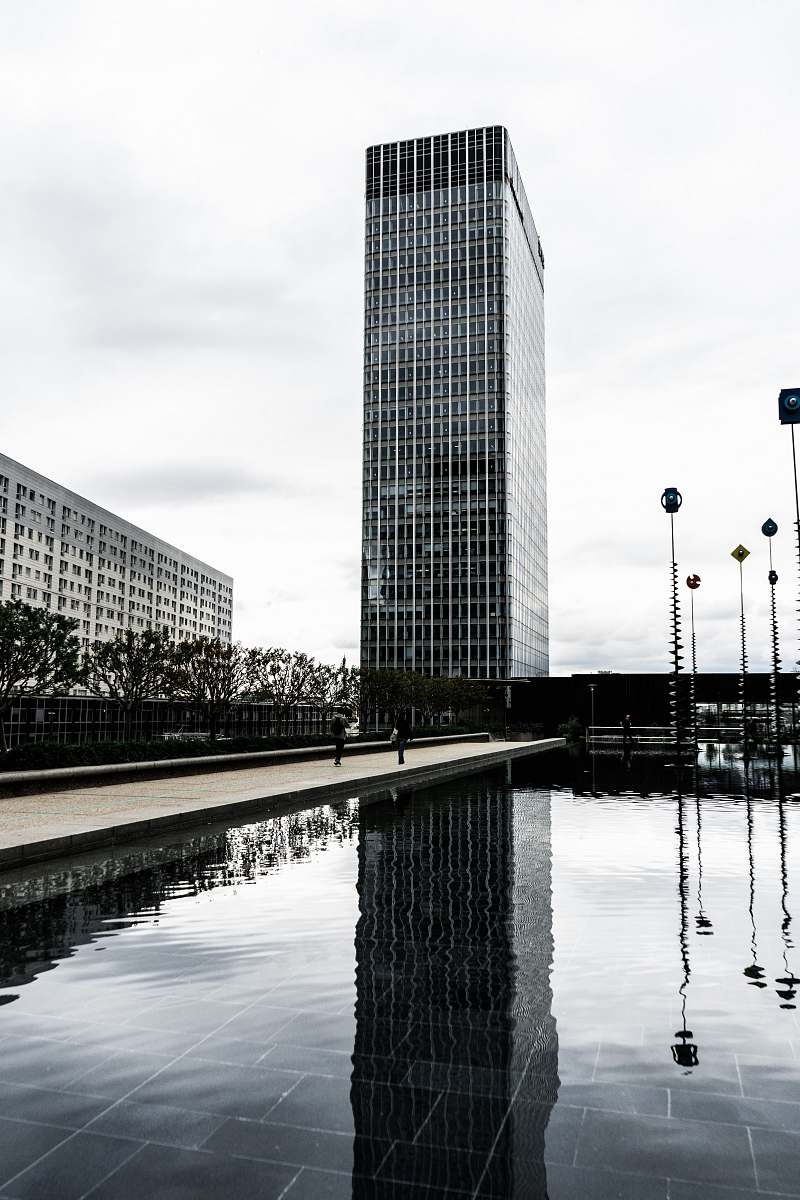 office building grayscale photography of building beside body of water city